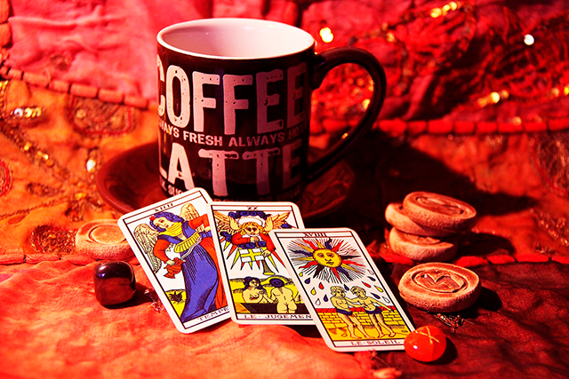 Chícara de café ao lado de cartas de tarot