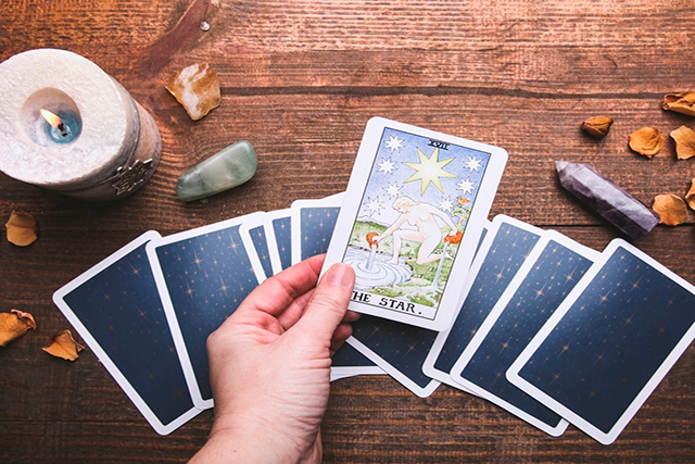 Pessoa pegando uma carta de tarot sobre o monte